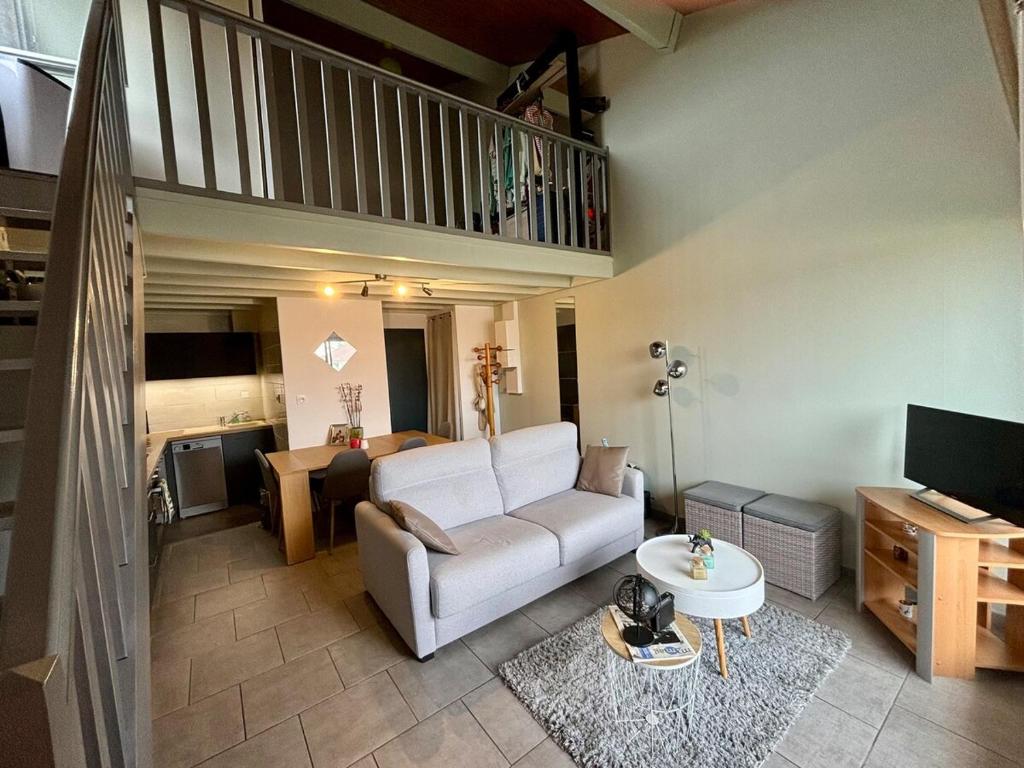 een woonkamer met een bank en een tafel bij Le Donjon - Agréable T2 centre ville - parking gratuit 2 min - in Mont-de-Marsan