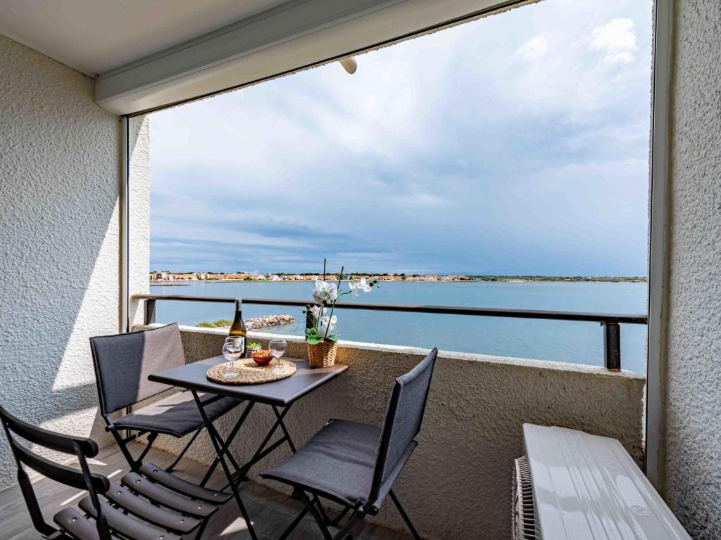 d'un balcon avec une table et des chaises et une vue sur l'eau. dans l'établissement Apartment Les Marquises-8 by Interhome, au Barcarès