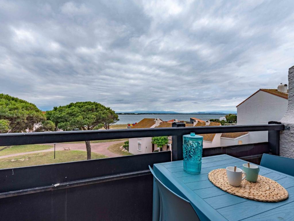 une table bleue sur un balcon avec vue sur l'eau dans l'établissement Apartment Antigua-8 by Interhome, au Barcarès