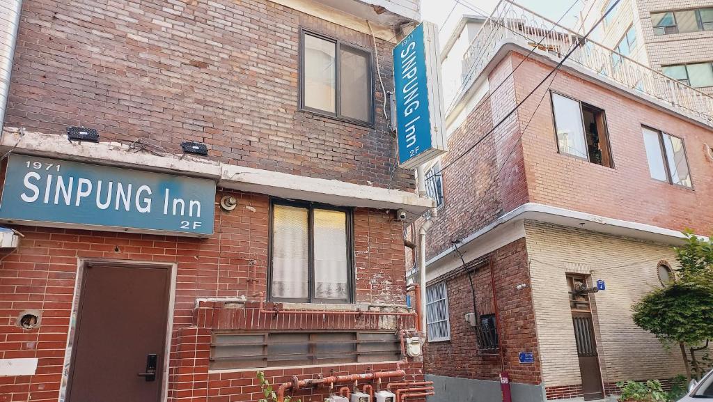 a brick building with a sign that reads singling inn at 1971 Sinpung Inn in Seoul