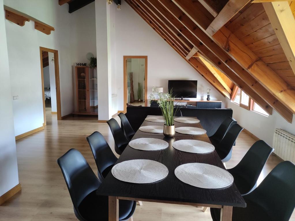 a dining room with a black table and black chairs at Alojamientos Turísticos TURBON - Campo in Campo