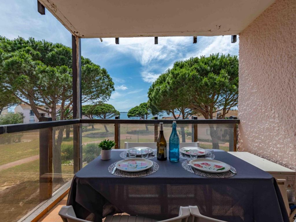 une table avec des bouteilles de vin et des assiettes sur un balcon dans l'établissement Apartment Antigua-5 by Interhome, au Barcarès