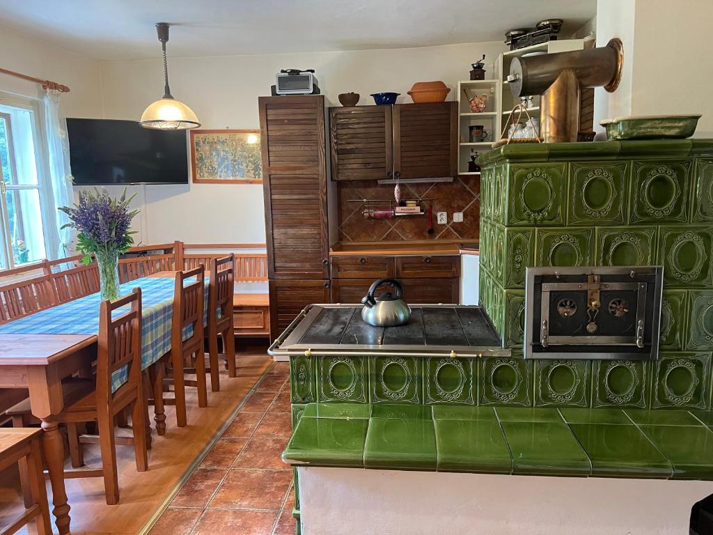 a kitchen with a green stove and a dining room at Chalupa Peťka in Rudník