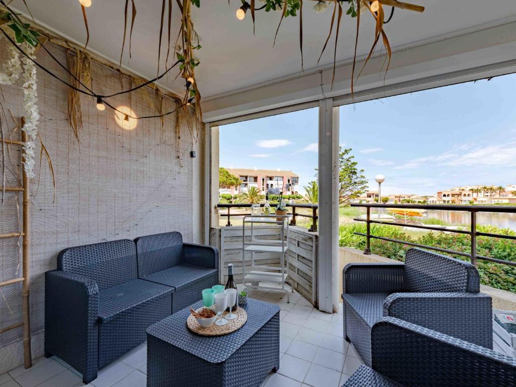 un patio avec deux chaises bleues et une table dans l'établissement Apartment Coudalère - Jamaica-6 by Interhome, au Barcarès