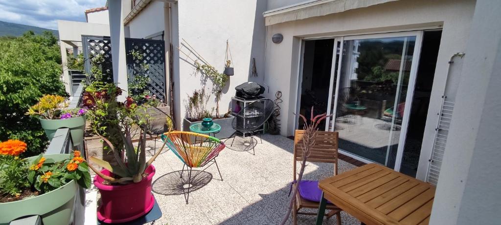 - une terrasse avec une table, des chaises et des fleurs dans l'établissement Pause Ciotadenne, à La Ciotat