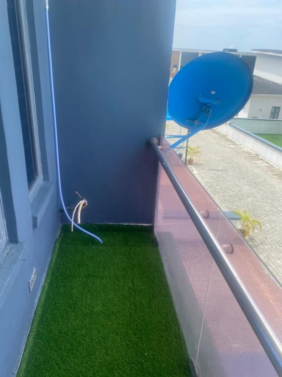 a balcony with green grass next to a window at ADES Home in Lekki