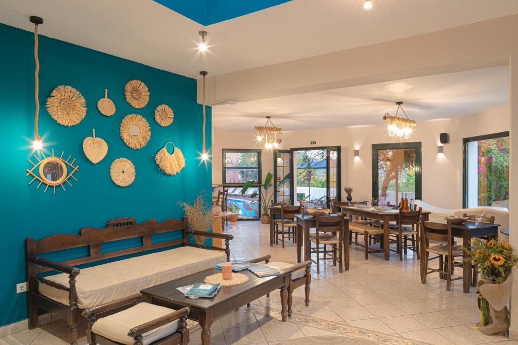 a living room with a bed and tables and chairs at Nisea Hotel Samos in Pythagoreio