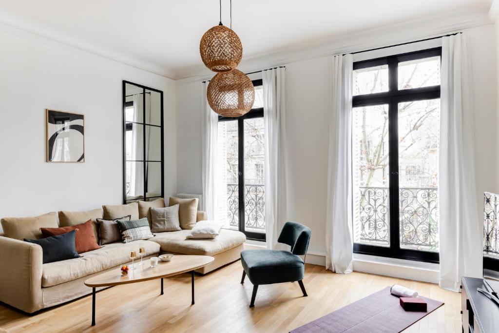 un salon avec un canapé et une table dans l'établissement Appartement Élégant à deux pas des Champs-Elysées, à Paris