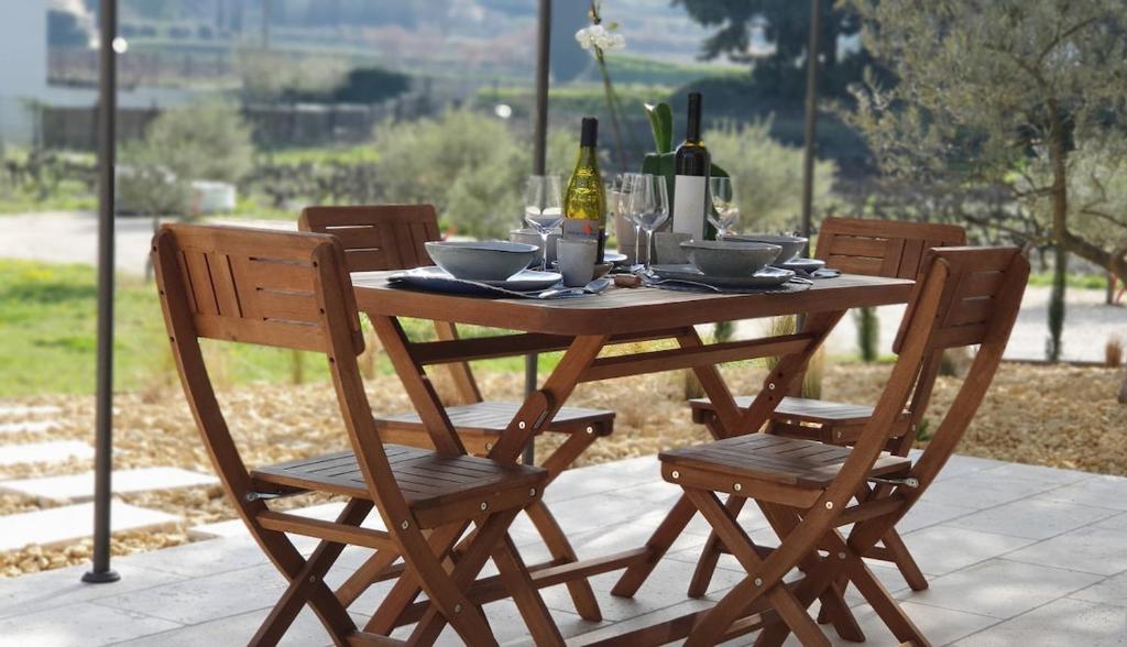 - une table en bois avec 2 chaises et une bouteille de vin dans l'établissement Charming Cohola gîte, all comforts, à Sablet