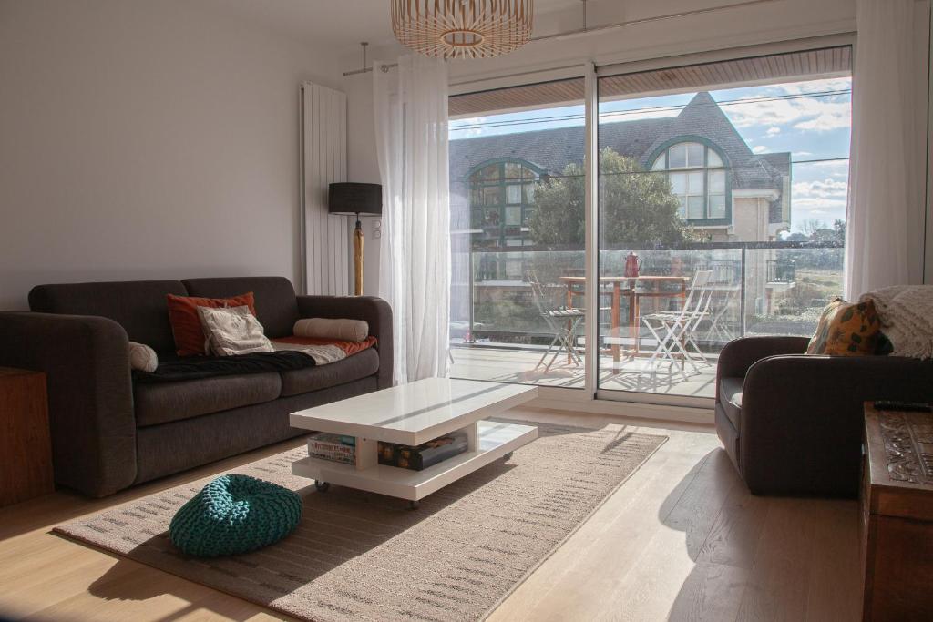 un salon avec un canapé et une table basse dans l'établissement Appartement neuf à 200 m de la plage tout confort, à Pornichet