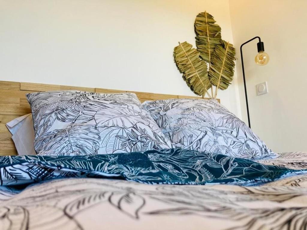 un lit avec des draps bleus et blancs et une plante dans l'établissement EDEN LES PINS, à Antibes