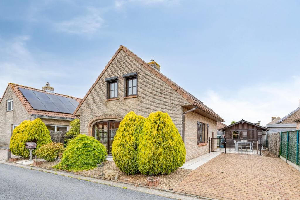 a brick house with trees in front of it at Sun Sea vakantiehuis in Middelkerke