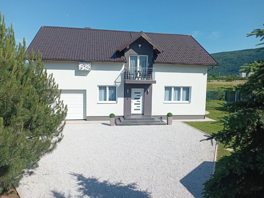 a white house with a black roof at Villa 'Whispering Pines' Ilidža in Sarajevo