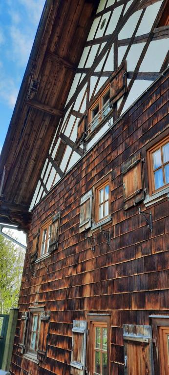 Un edificio de ladrillo con ventanas a los lados. en Selbstversorgerhütte N 15 Kleinwalsertal, en Hirschegg