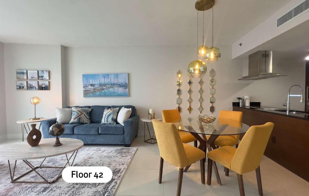 a living room with a blue couch and a table and chairs at MVR - Skyline & Spa for Brickell Perfection in Miami