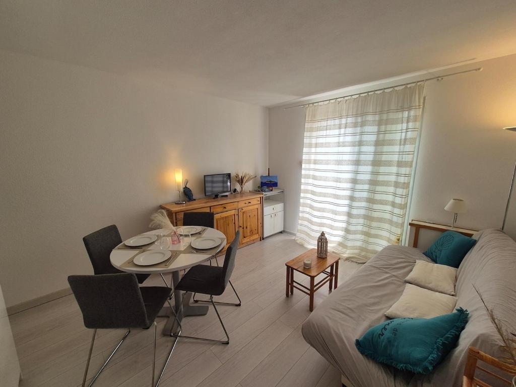 un salon avec une table et un canapé dans l'établissement Appartement T2 La Baie des Anges, à La Ciotat