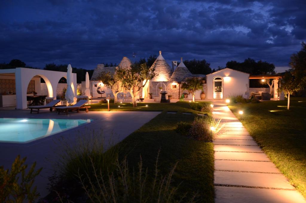 a villa with a swimming pool at night at Trulli di V E N E R E in Castellana Grotte