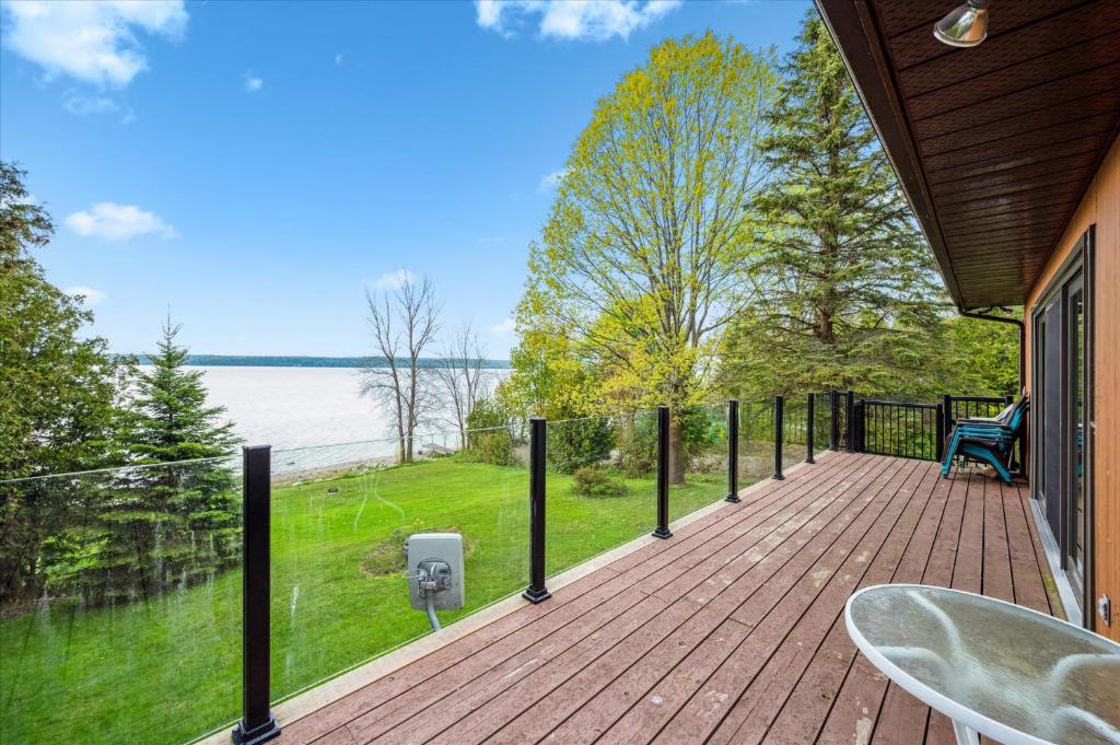 a wooden deck with a view of the water at By The Bay Retreat Waterfront Sunset View in Wiarton