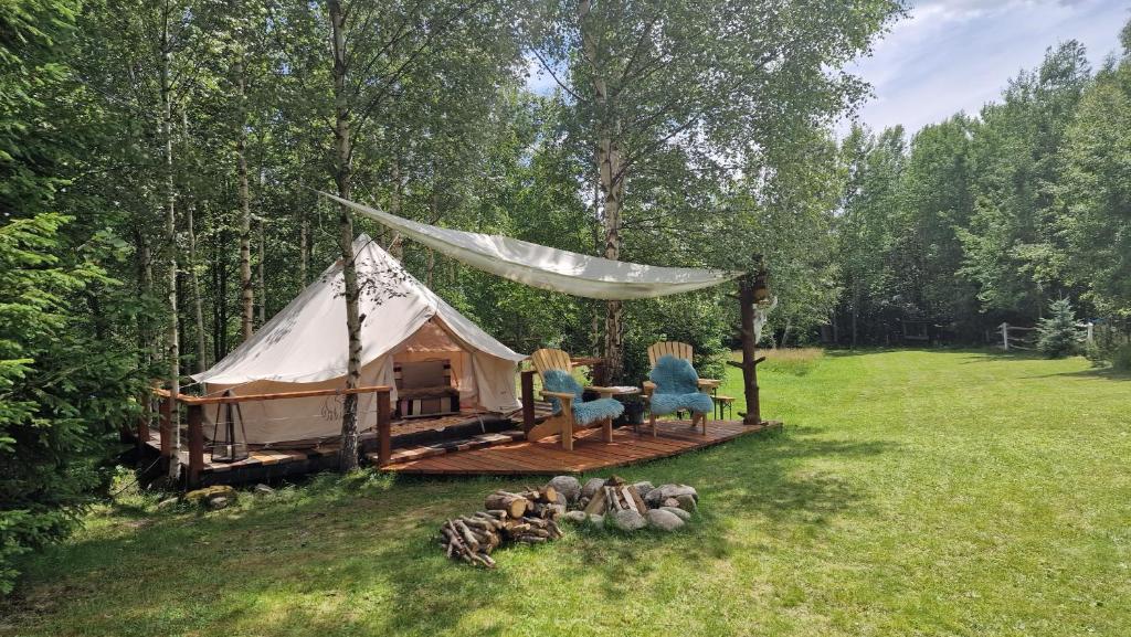a yurt with a table and chairs in a field at Glamping Štôla Lesný duch in Vyšné Hágy