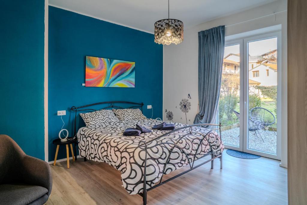 a bedroom with a bed with a blue wall at Casa LUIS in Luino