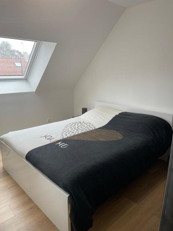 Ce lit se trouve dans une chambre blanche dotée d'une couverture noire. dans l'établissement Chambre double lit King size, à La Celle-sous-Gouzon