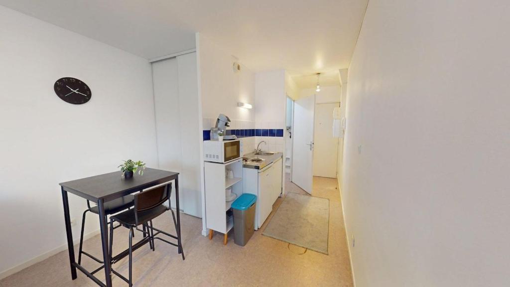 - une petite cuisine avec une table, une table et une chaise dans l'établissement Studio - Jean-Jacques Rousseau, au Havre