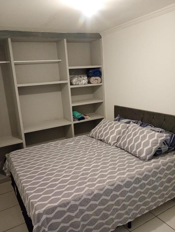 a bedroom with a bed and open shelves at JM Flat in Petrolina