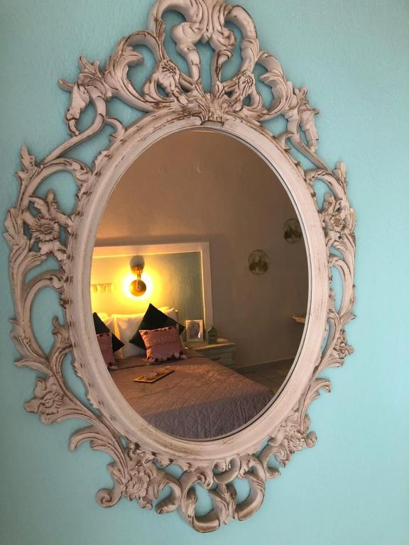 a mirror on a wall with a bed in a room at vranas hotel in Skala Sotiros