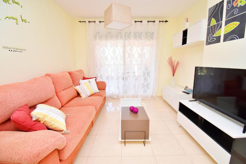 a living room with a couch and a flat screen tv at Expoholidays - Brisas de Almerimar in Almerimar