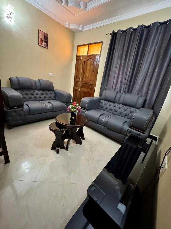 Una sala de estar con sofás y una mesa de café. en Watra Apartments, en Dodoma