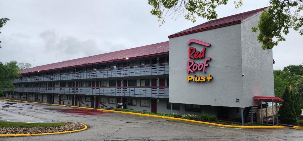 un edificio con un techo rojo y una señal en él en Red Roof Inn PLUS+ Pittsburgh East - Monroeville, en Monroeville