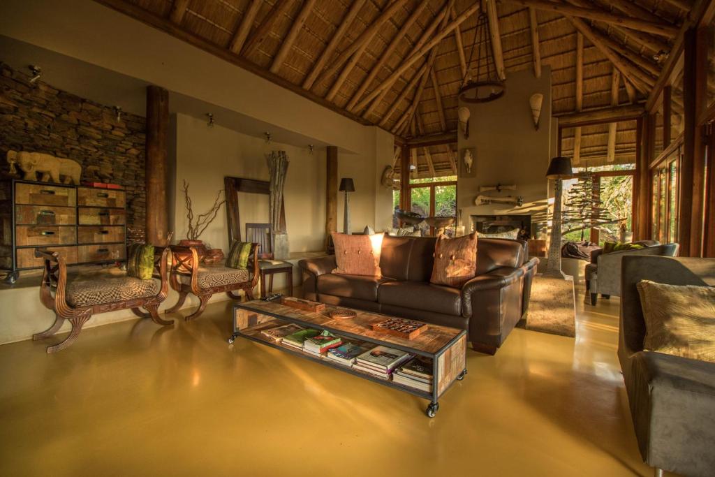 Etali Safari Lodge في محميّة ماديكوي الطبيعيّة للطرائد: غرفة معيشة مع أريكة وطاولة