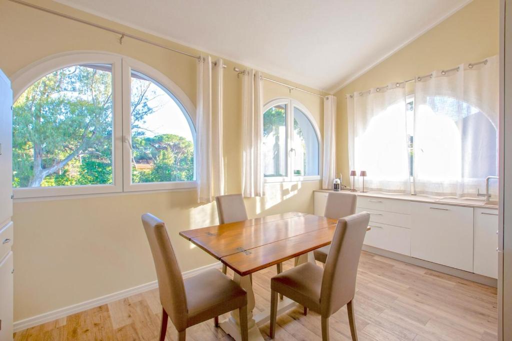 a dining room with a wooden table and chairs at Pellicano Suite Apartment in Marina di Grosseto