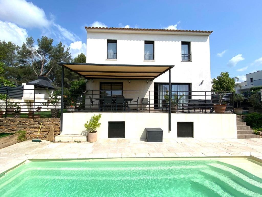 une maison avec une piscine devant une maison dans l'établissement La Marjolaine Villa avec piscine, à La Ciotat