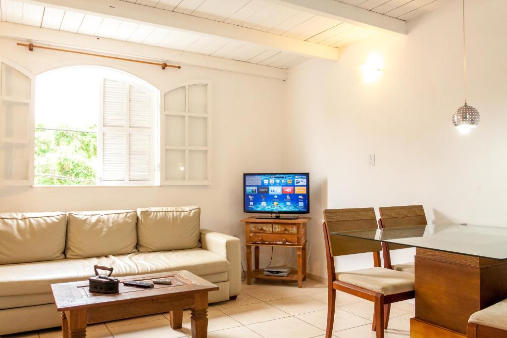 a living room with a couch and a tv at Apartamento Búzios in Búzios