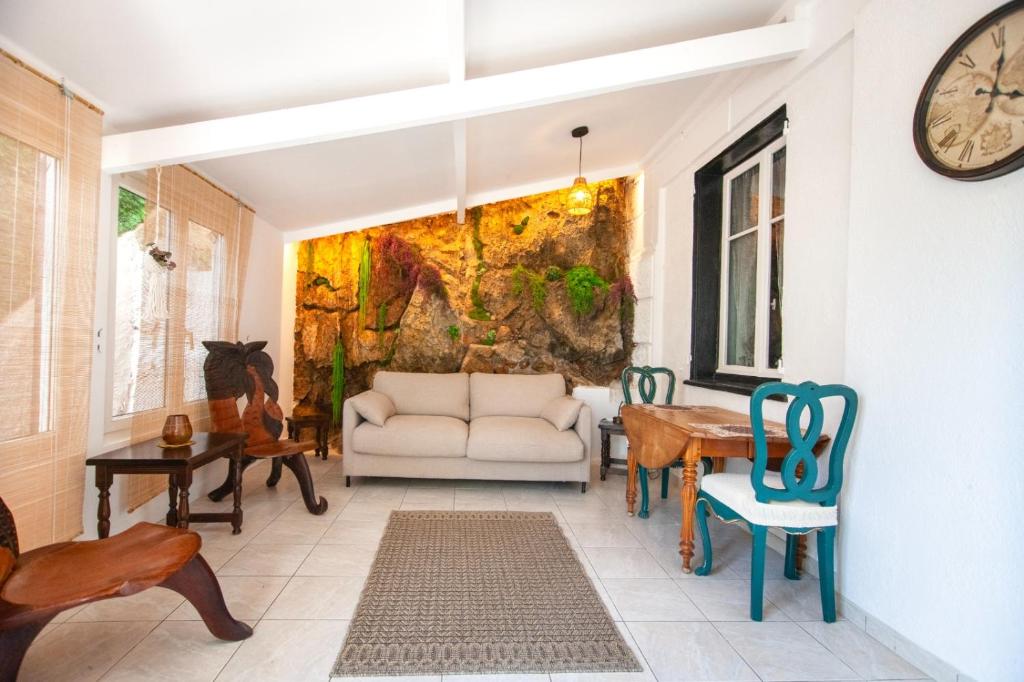 un salon avec un canapé et une horloge au mur dans l'établissement Cap de Nice, à Nice