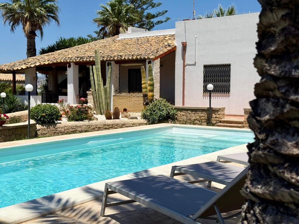 une piscine avec deux chaises et une maison dans l'établissement Villa Urùca, à Cava dʼAliga