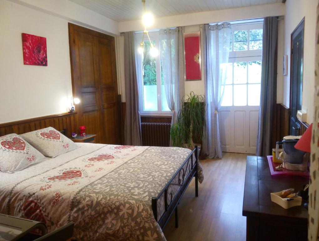 a bedroom with a bed and a window at Les Clés du Parc in Combrand