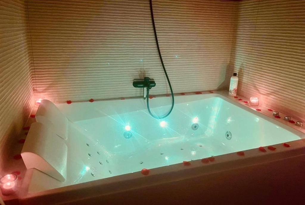 d'une baignoire avec douche éclairée. dans l'établissement Studio romantique avec baignoire balnéothérapie duo proche de Colmar et Kaysersberg pour 2 personnes, à Lapoutroie