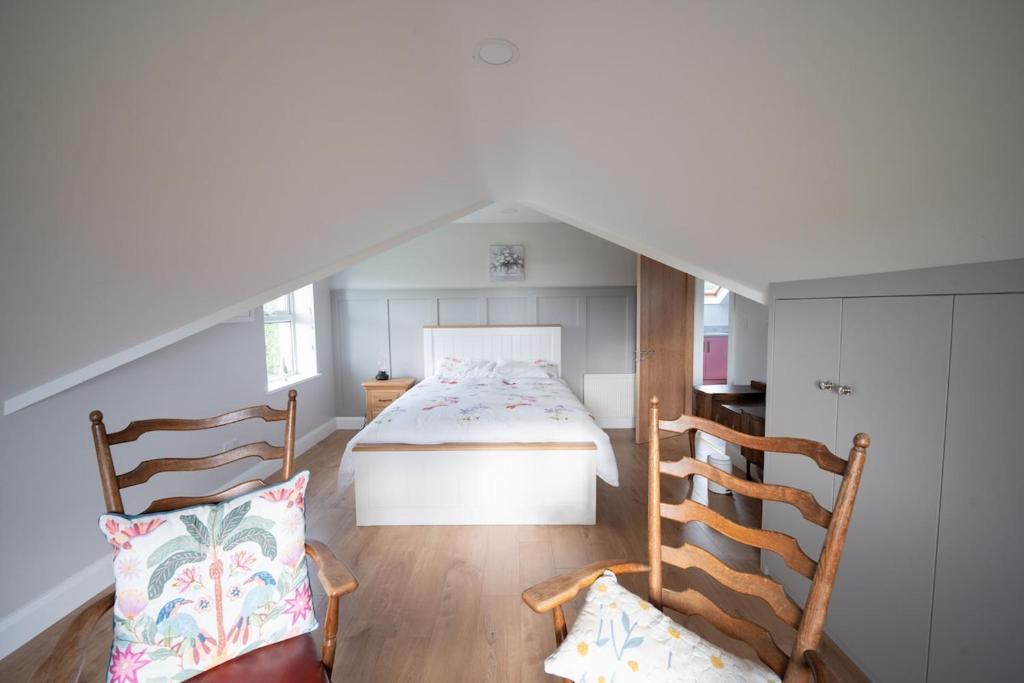 a bedroom with a bed and two chairs at The Swilly Suite in Castlequarter