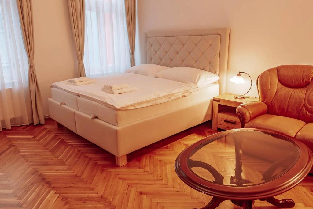a bedroom with a bed and a table and a chair at Aparmány Rozálie in Česká Lípa