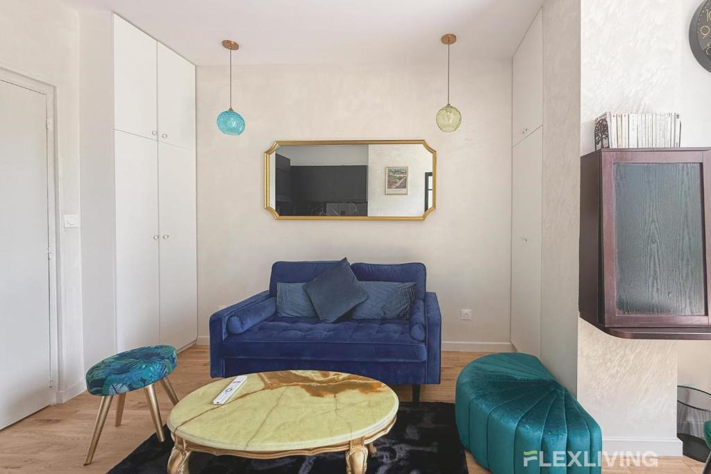 un salon avec un canapé bleu et un miroir dans l'établissement Bright apartment with garden close to the metro, à Paris