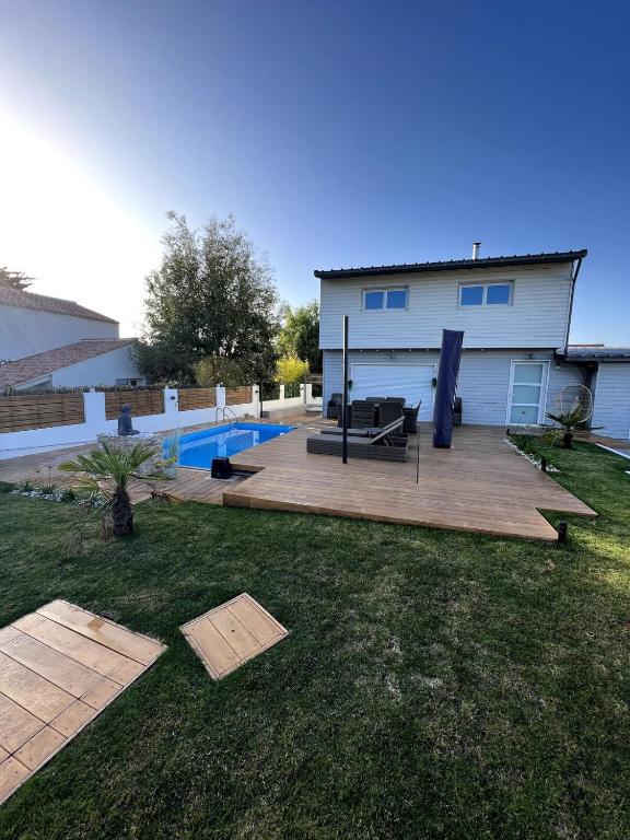 une arrière-cour avec une terrasse et une piscine dans l'établissement Maison charmante avec piscine - 6 personnes - proche mer, à Saint-Gilles-Croix-de-Vie
