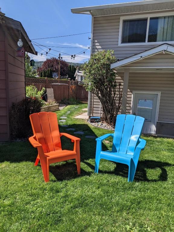 two colorful chairs sitting in the grass in a yard at Private SweetSuite 1 Bdrm Bathroom mini-kitchen in Kamloops