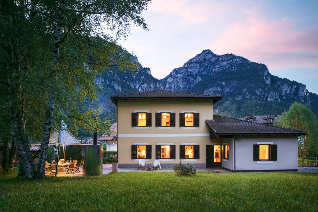a house with a mountain in the background at VILLA MARGHERITA - 5 minutes from Dolomiti Super Ski in Ziano di Fiemme