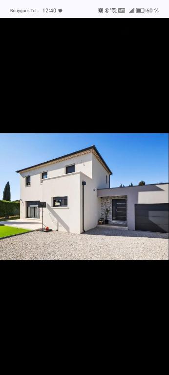 une grande maison blanche avec une grande allée dans l'établissement Villa Moderne Piolenc, à Piolenc