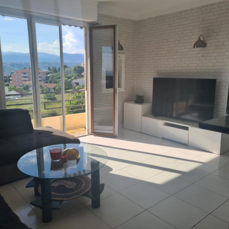 un salon avec un canapé et une table en verre dans l'établissement Beautiful 3-room apartment sea view, à Nice