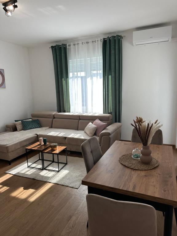 バニャ・ルカにあるLumière Apartmentのソファとテーブルのあるリビングルーム