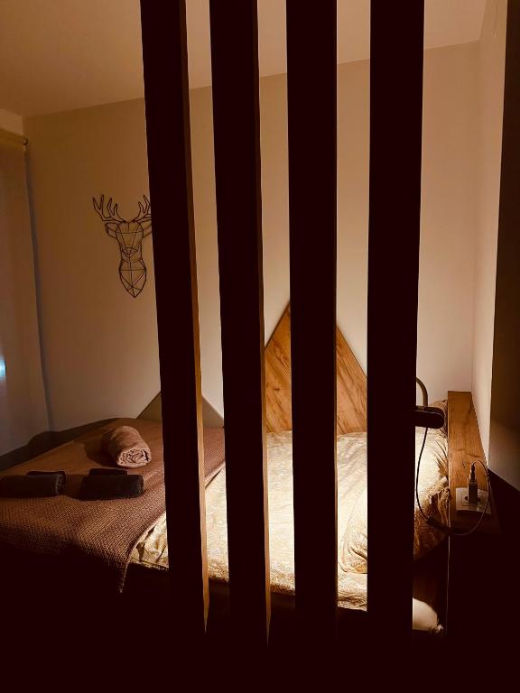 a bed is seen through a barred window at Studio Apartman Nomad Divčibare in Divčibare