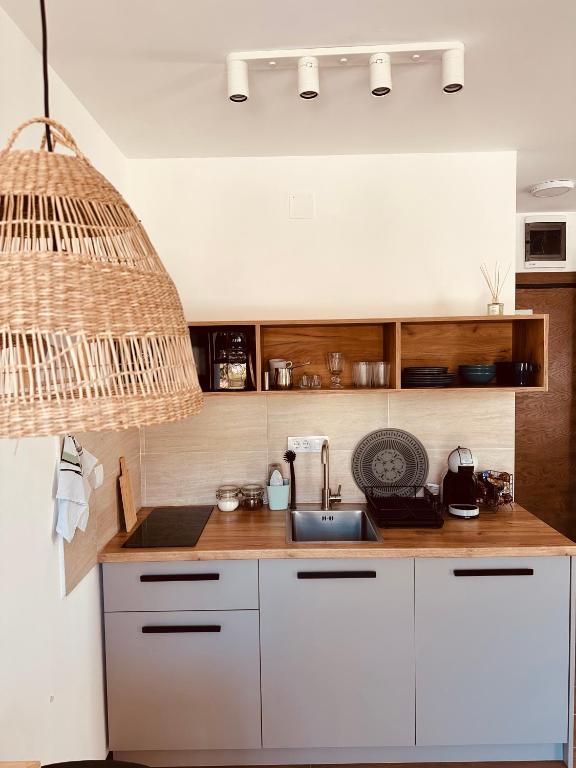 a kitchen with white cabinets and a sink at Studio Apartman Nomad Divčibare in Divčibare